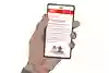 En hand håller i en mobil, där UMO:s artikel om jämställdhet visas. Illustration.